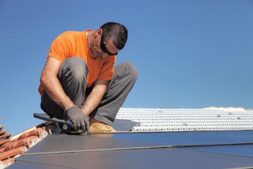 在屋顶上安装太阳能电池板的技术人员